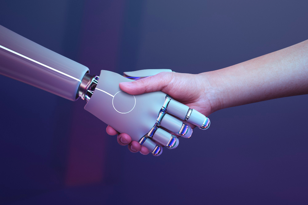 imagen de la mano de un robot y de la mano de un humano estrechándose las mismas