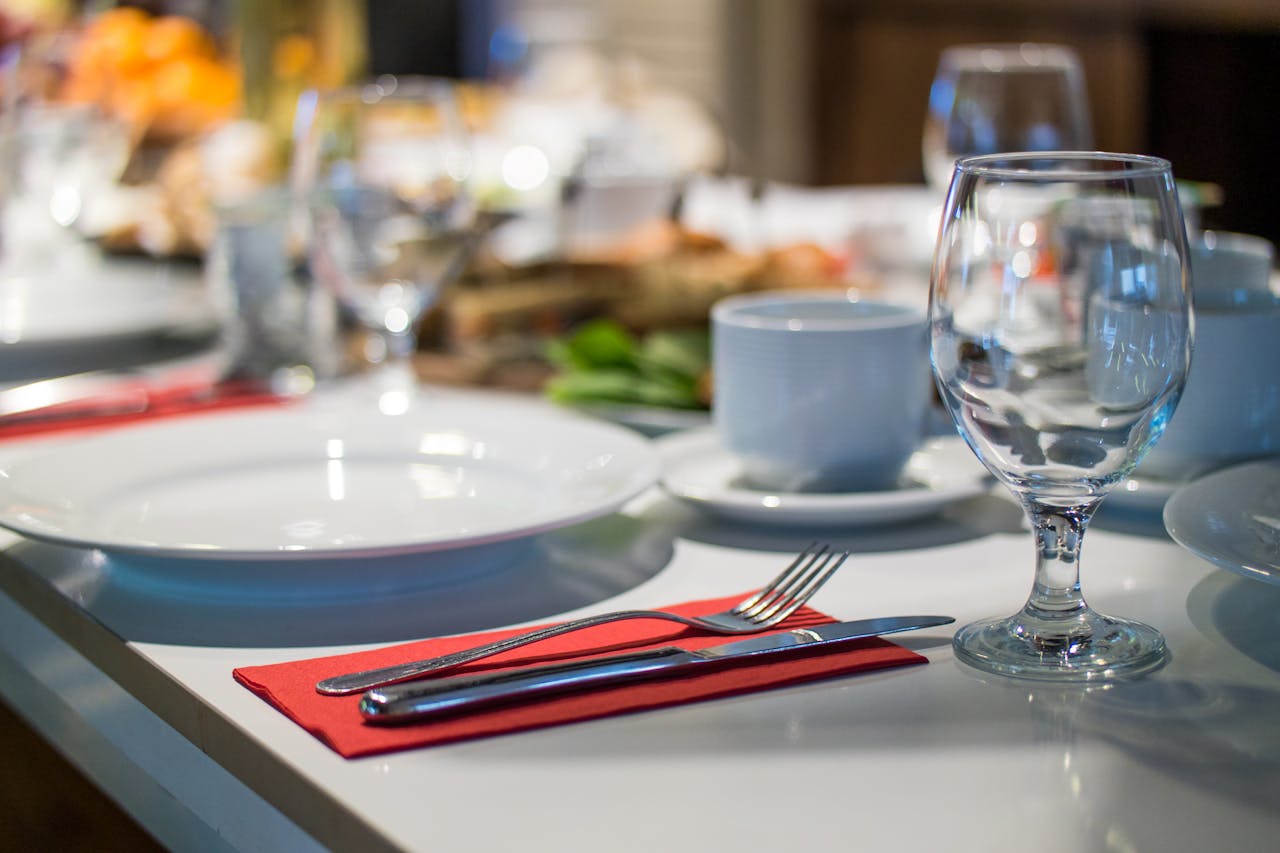 imagen de una mesa de un restaurante donde destacan varias copas, platos, cubiertos...
